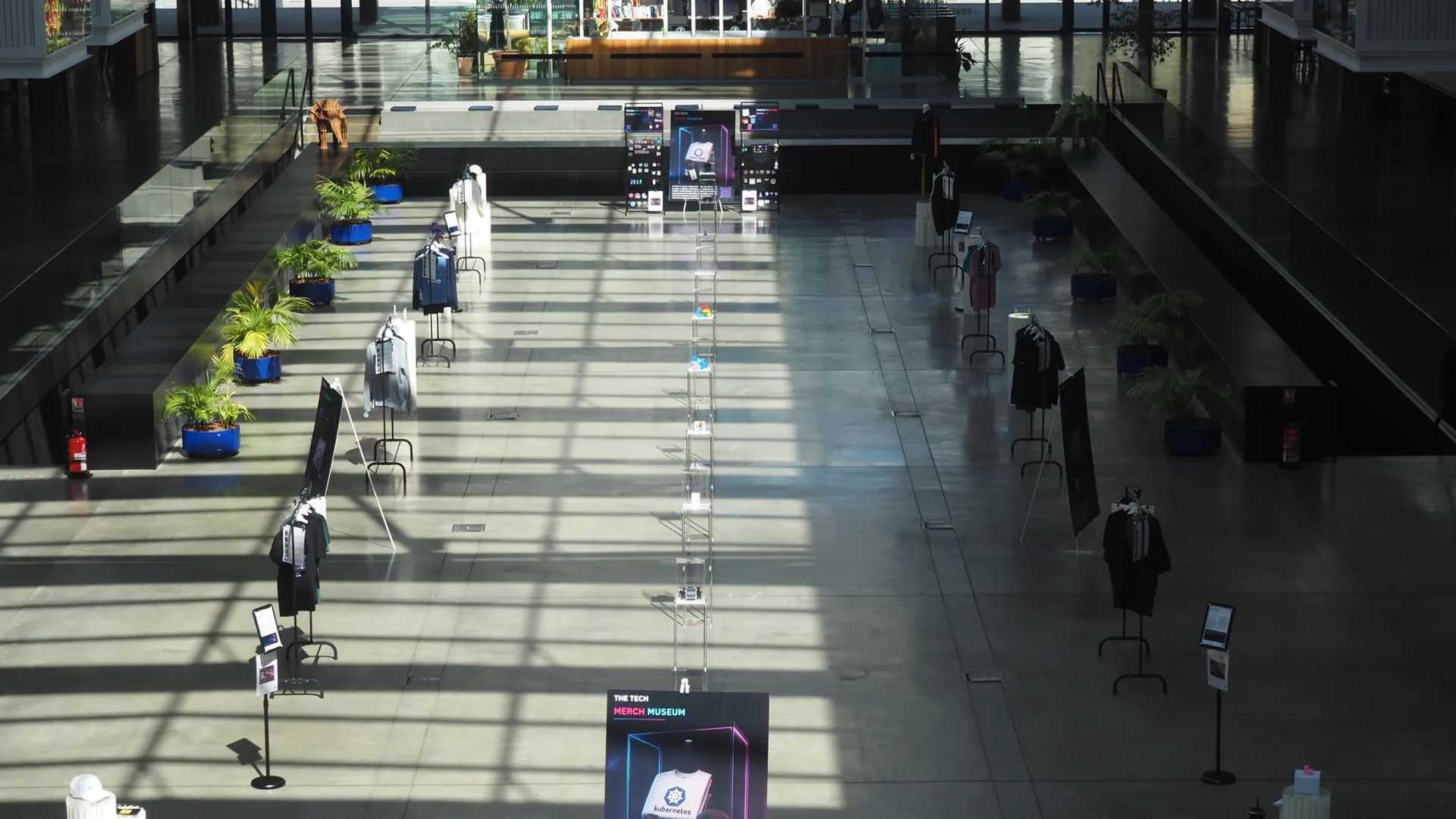Overhead view of the Tech Merch Museum at STATION F, with mannequins wearing tech merch, acrylic plinths and information panels running the length of the hall